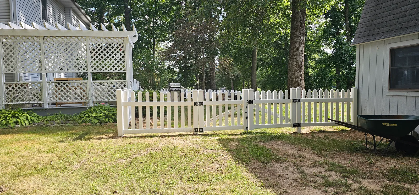 The 8-foot double-drive gate and 3-foot walk gate hung on black anodized hardware between the pergola and the shed